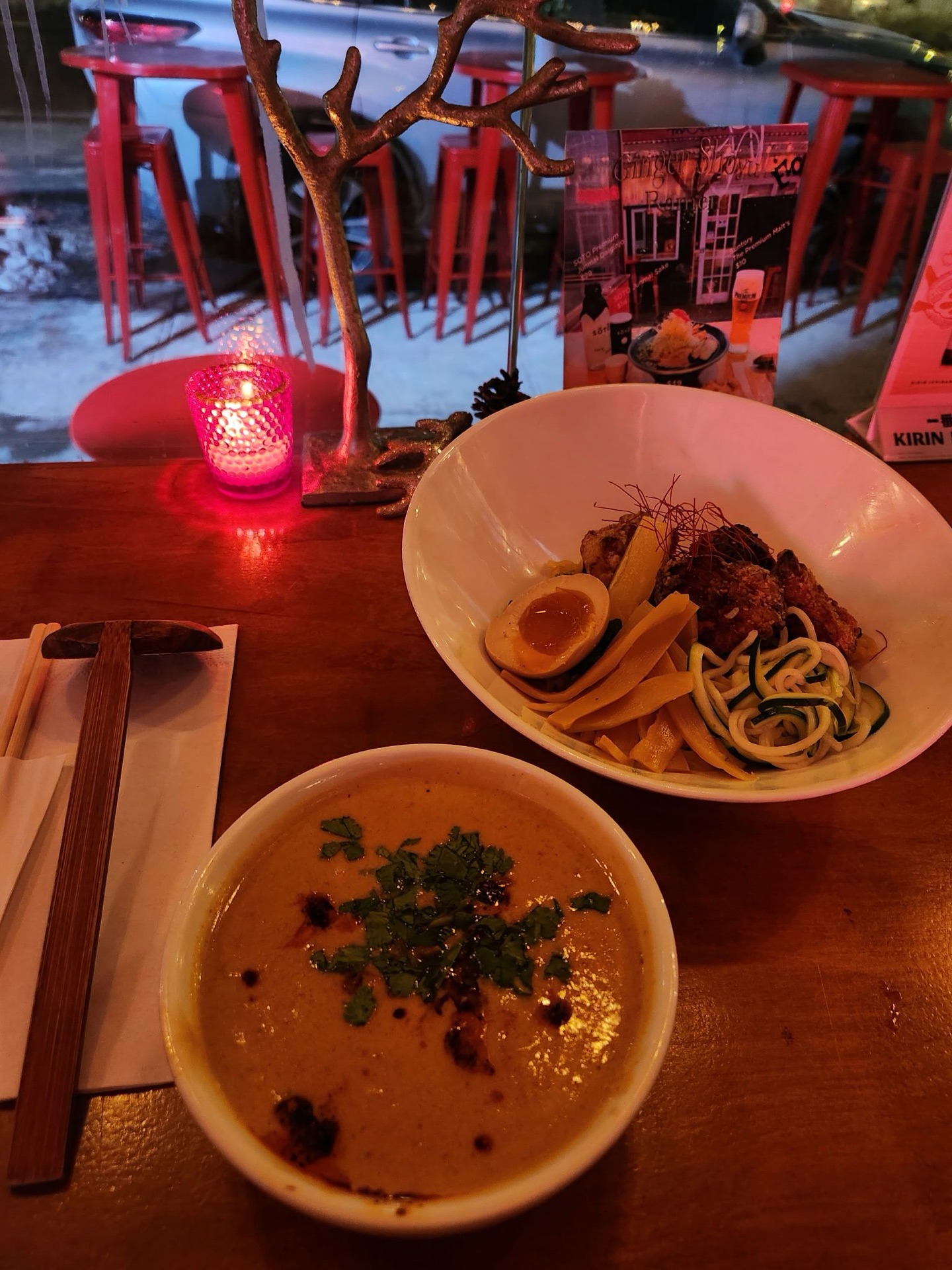 Mr. Taka tsukemen and a creamy vegan curry bowl plated at a candlelit table