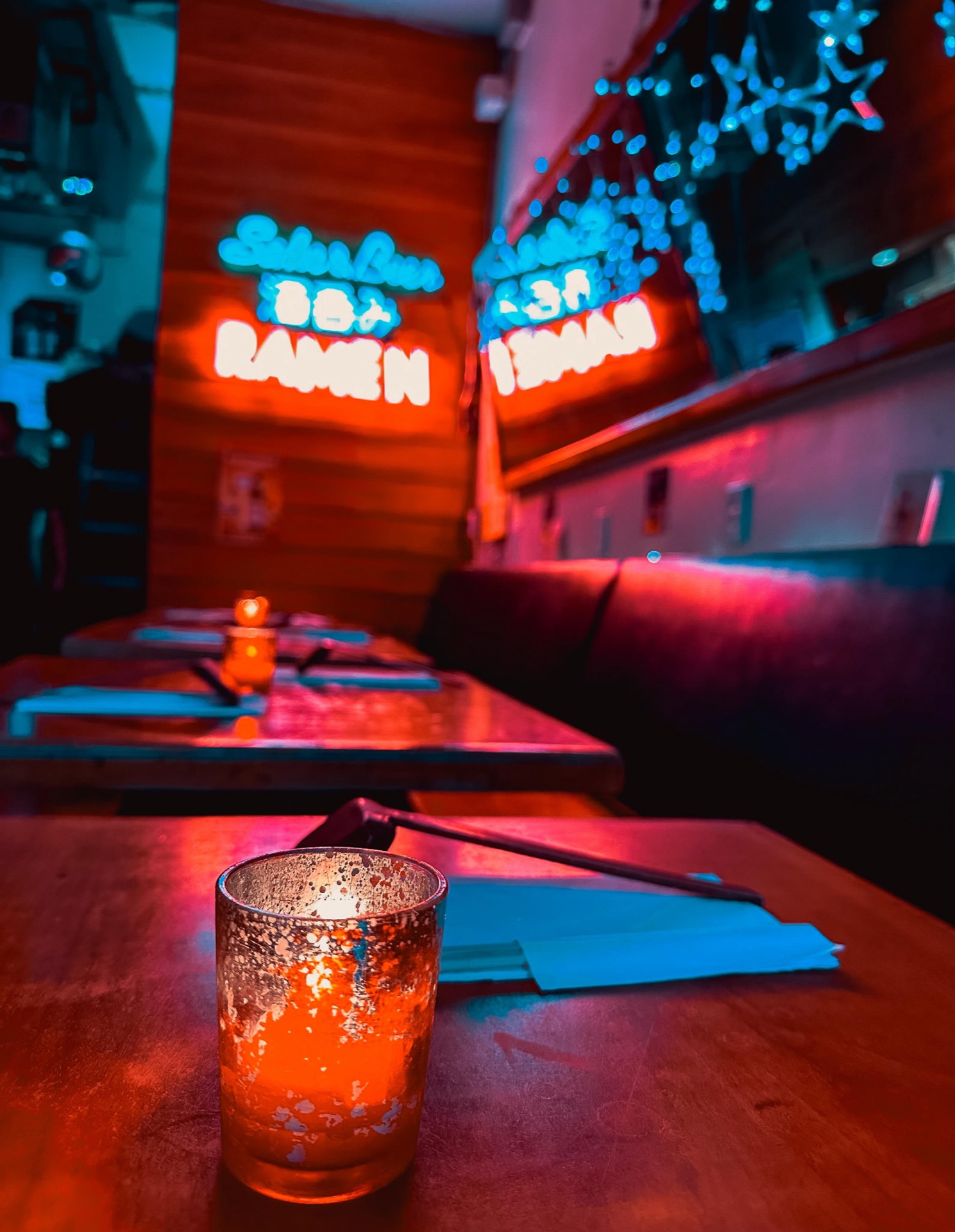 Evening view of Mr. Taka Ramen dining room with neon ramen sign in the background